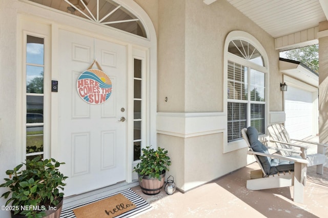 property entrance featuring stucco siding and covered porch