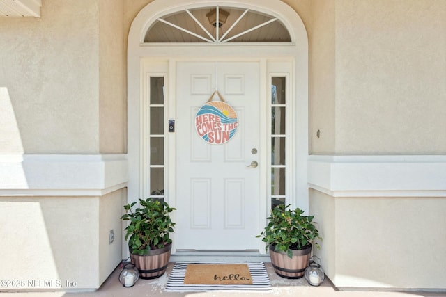 view of exterior entry with stucco siding