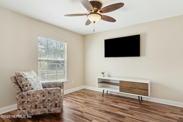 living area featuring wood finished floors, ceiling fan, and baseboards