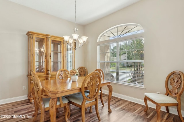 dining area with wood finished floors, a chandelier, and baseboards
