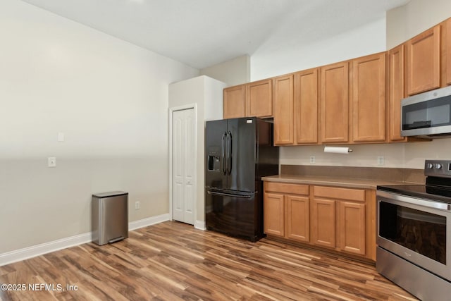 kitchen with wood finished floors, stainless steel appliances, and baseboards