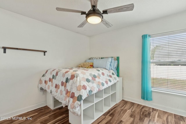 bedroom featuring a ceiling fan, wood finished floors, and baseboards
