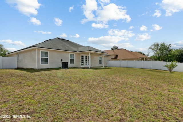 back of house with fence, a yard, central air condition unit, and french doors