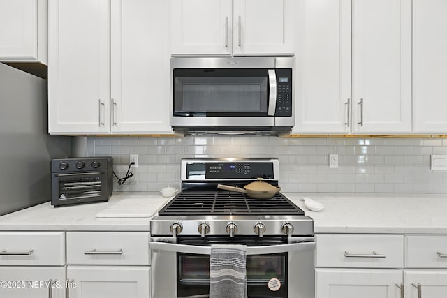 291 Greenway Ln, Saint Augustine, FL 32092 - kitchen featuring white cabinets, light stone countertops, stainless steel appliances, and tasteful backsplash