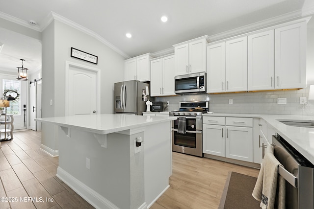 291 Greenway Ln, Saint Augustine, FL 32092 - kitchen with appliances with stainless steel finishes, recessed lighting, decorative backsplash, a kitchen island, and ornamental molding