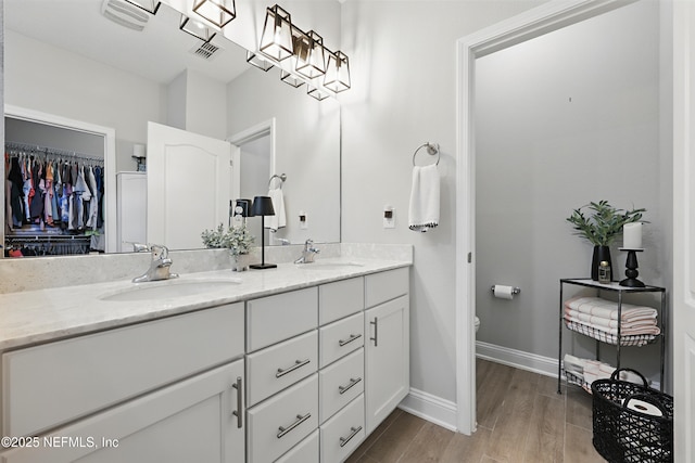 291 Greenway Ln, Saint Augustine, FL 32092 - full bath with double vanity, a sink, wood finished floors, and visible vents