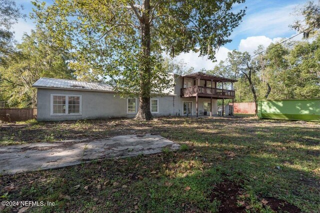 rear view of house featuring fence, a yard, stucco siding, french doors, and metal roof