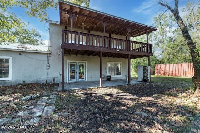 back of house with metal roof, fence, stucco siding, a patio area, and a deck