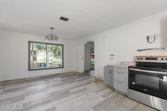 kitchen featuring an inviting chandelier, visible vents, arched walkways, stainless steel electric stove, and light wood-style flooring