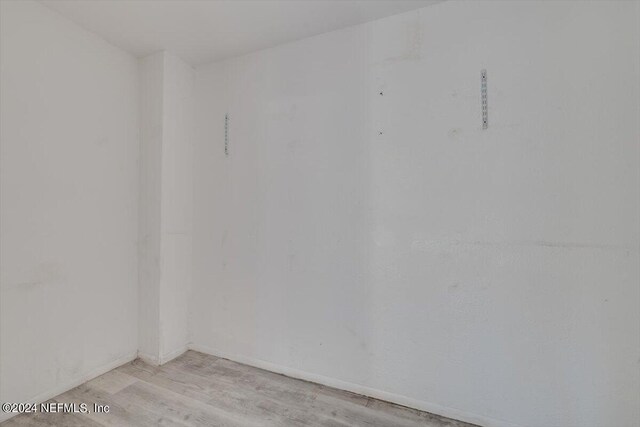 unfurnished room with baseboards and light wood-style floors