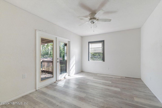 empty room with wood finished floors, a textured ceiling, baseboards, and ceiling fan