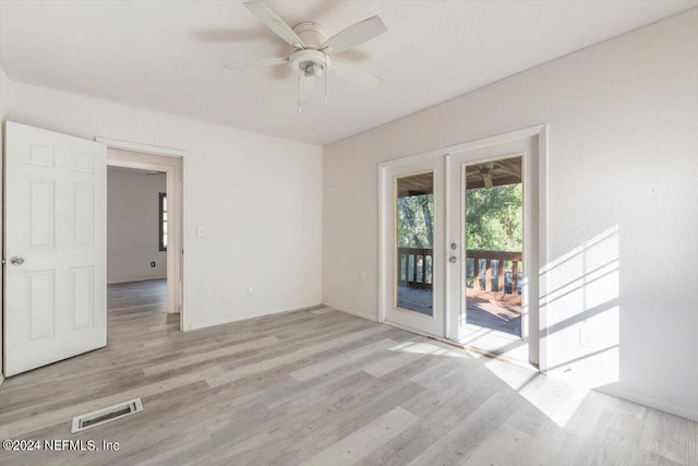 spare room with wood finished floors, visible vents, a ceiling fan, and french doors