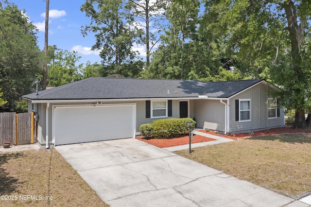 ranch-style house with roof with shingles, a garage, fence, a front lawn, and concrete driveway