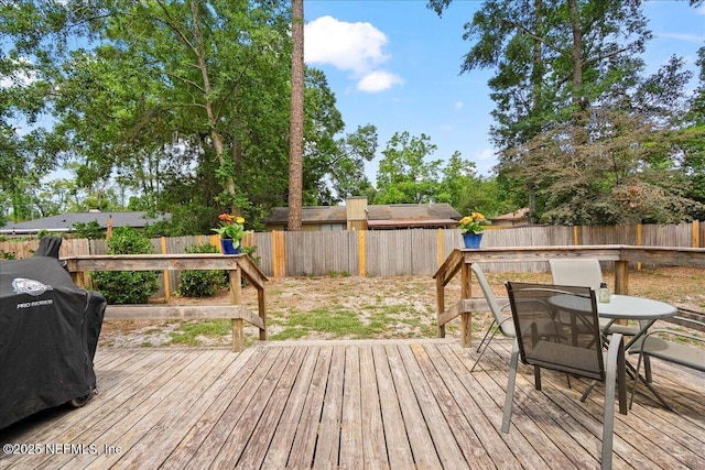 deck with outdoor dining area and a fenced backyard