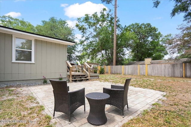 view of patio featuring a deck and a fenced backyard