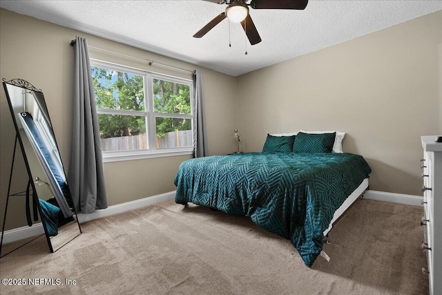 bedroom with carpet flooring, a textured ceiling, baseboards, and a ceiling fan