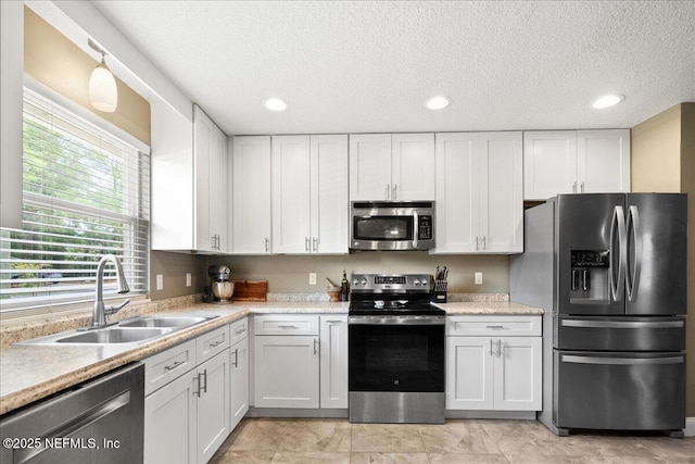 kitchen featuring light countertops, a sink, white cabinets, and stainless steel appliances