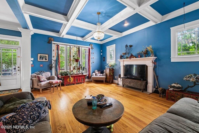 living room with wood finished floors, a wealth of natural light, and coffered ceiling
