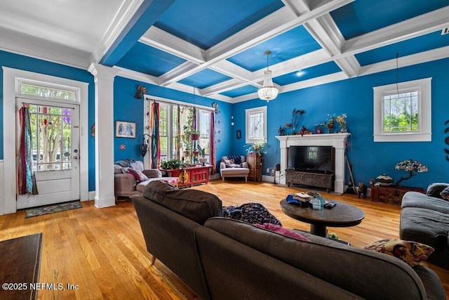 living room with ornamental molding, coffered ceiling, and wood finished floors