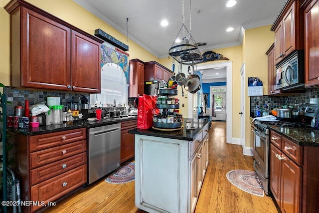kitchen with stainless steel appliances, backsplash, ornamental molding, and a kitchen island