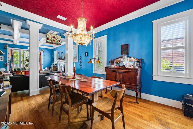 dining room with a chandelier, wood finished floors, a healthy amount of sunlight, and ornamental molding