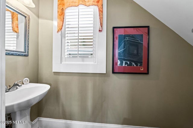 bathroom with vaulted ceiling and a sink