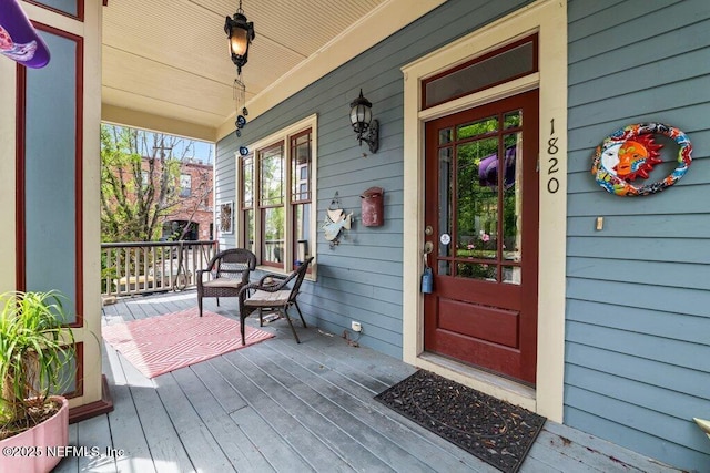 view of exterior entry featuring covered porch