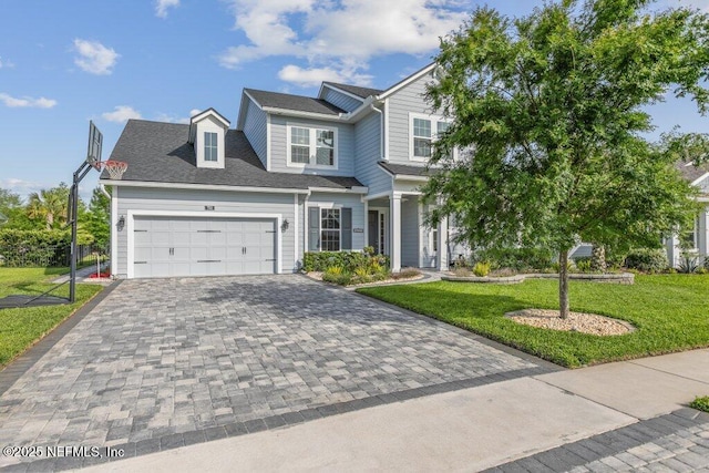 view of front of home featuring decorative driveway, a garage, and a front lawn
