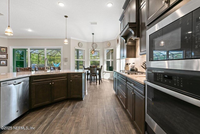 kitchen with a sink, ornamental molding, stainless steel appliances, and dark wood-style floors