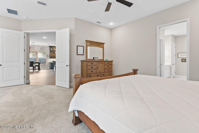 carpeted bedroom with recessed lighting, visible vents, and ensuite bathroom