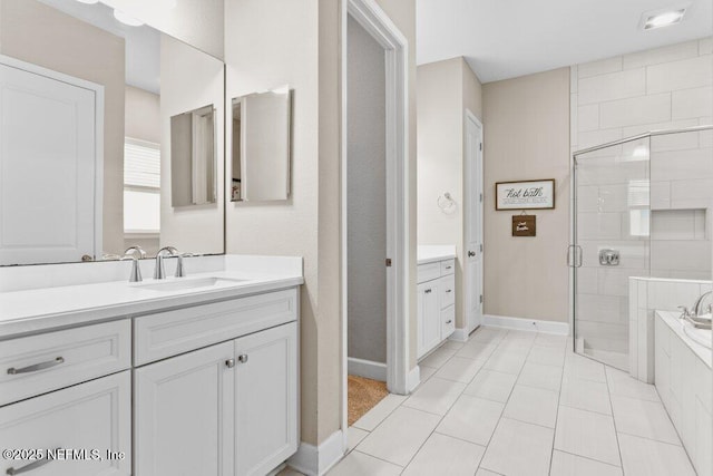 bathroom featuring baseboards, vanity, tile patterned floors, and a shower stall