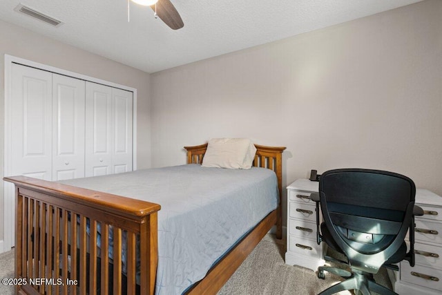 bedroom with ceiling fan, visible vents, and a closet