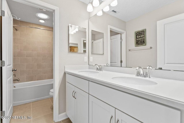 bathroom featuring toilet, tile patterned floors, visible vents, and a sink