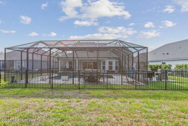 rear view of house featuring fence, a fenced in pool, a patio area, a lawn, and glass enclosure