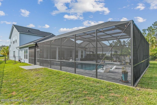 rear view of property with fence, a lanai, a fenced in pool, a lawn, and a patio