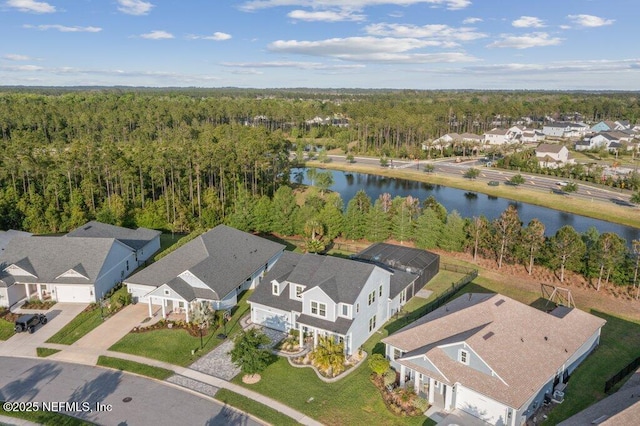birds eye view of property featuring a water view, a residential view, and a forest view