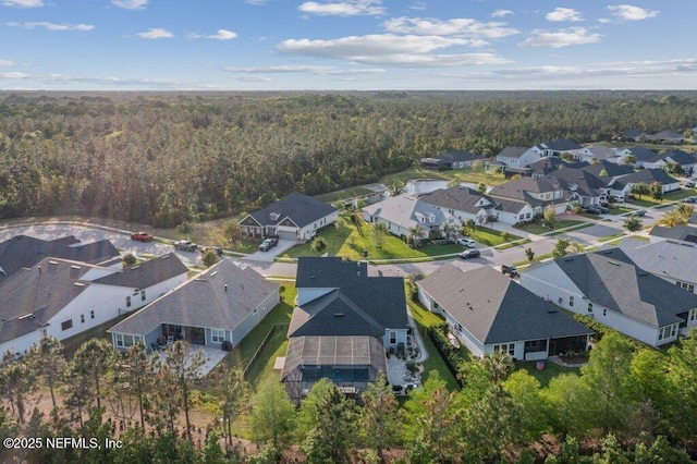 drone / aerial view with a forest view and a residential view
