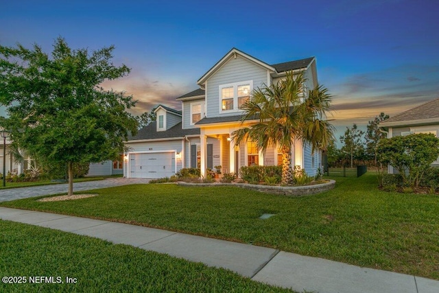 traditional-style home with an attached garage, driveway, and a front lawn