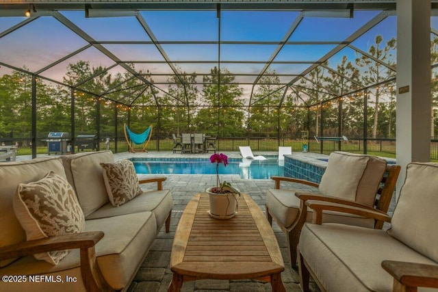 pool at dusk with a fenced in pool, a patio, a lanai, and outdoor lounge area