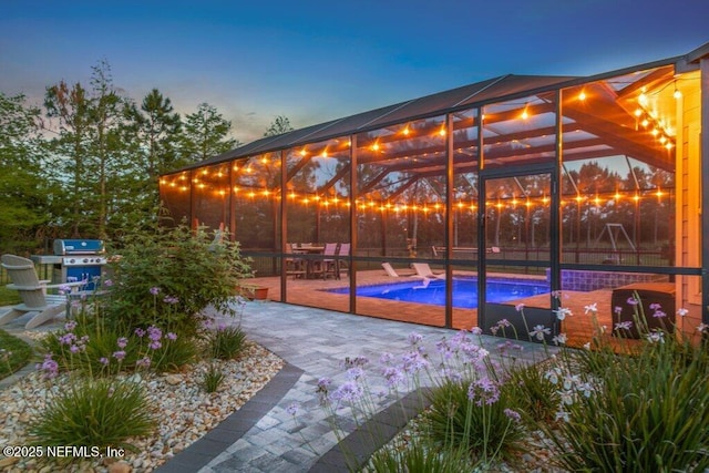 view of patio / terrace with glass enclosure and an outdoor pool
