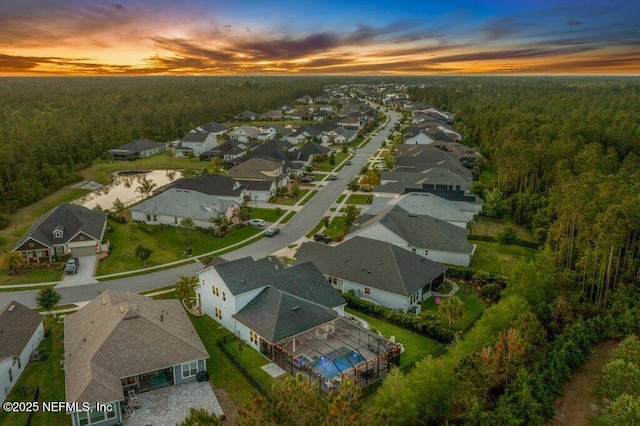 aerial view at dusk with a view of trees and a residential view