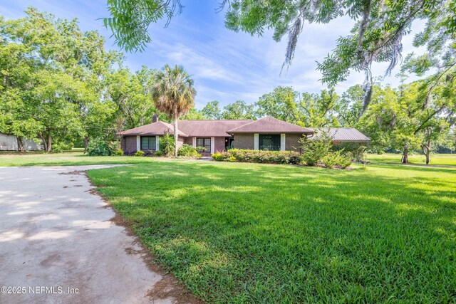 ranch-style house with a front yard, driveway, and brick siding