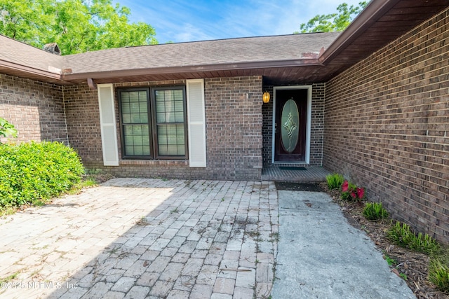 doorway to property with a patio and brick siding