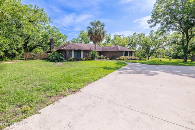 ranch-style home featuring a front lawn and driveway