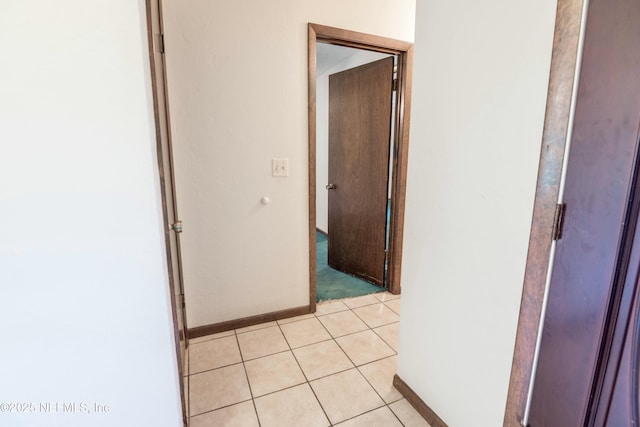 hallway with baseboards and light tile patterned floors