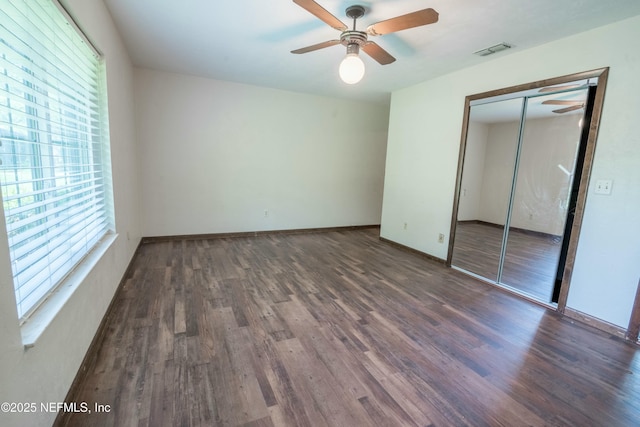 unfurnished bedroom with visible vents, ceiling fan, baseboards, a closet, and wood finished floors