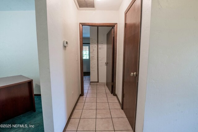 hallway featuring visible vents and light tile patterned floors