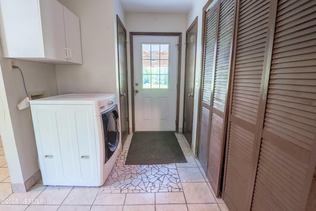laundry area featuring light tile patterned flooring, cabinet space, and washing machine and dryer