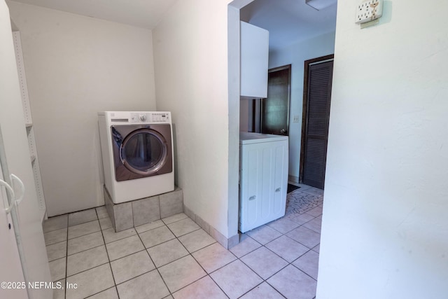 washroom featuring light tile patterned floors, washer / dryer, laundry area, and baseboards