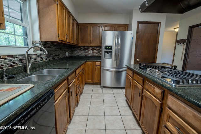 kitchen featuring appliances with stainless steel finishes, extractor fan, decorative backsplash, and a sink